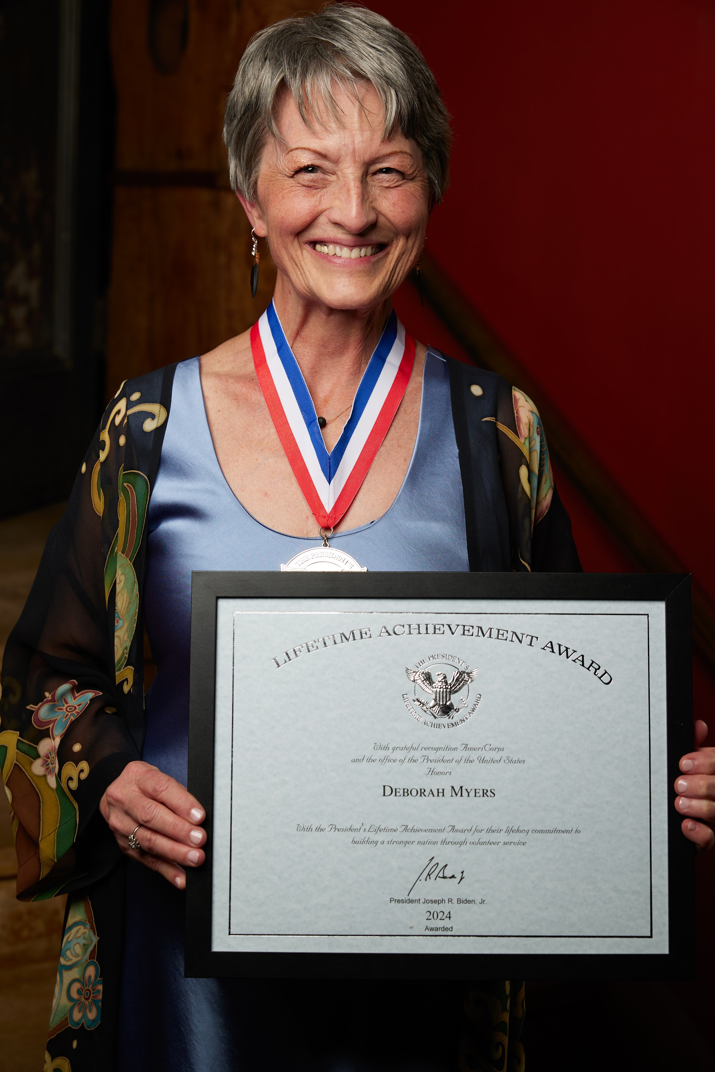 Deborah Myers with president's award certificate and medal